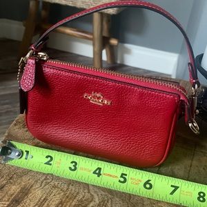 Coach Nolita 15 mini pouch with gold hardware and strap.